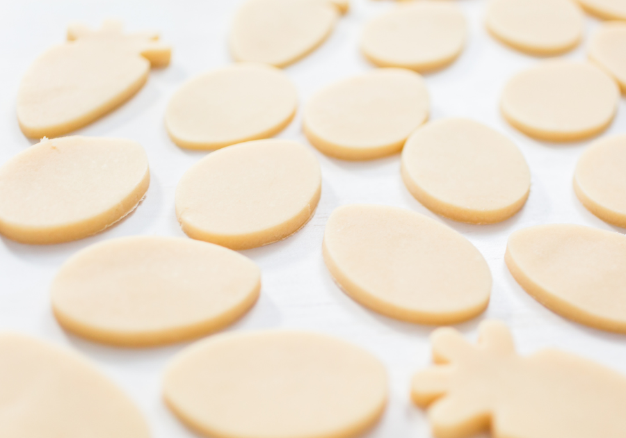 image of cut out easter themed sugar cookies laying on a baking sheet.