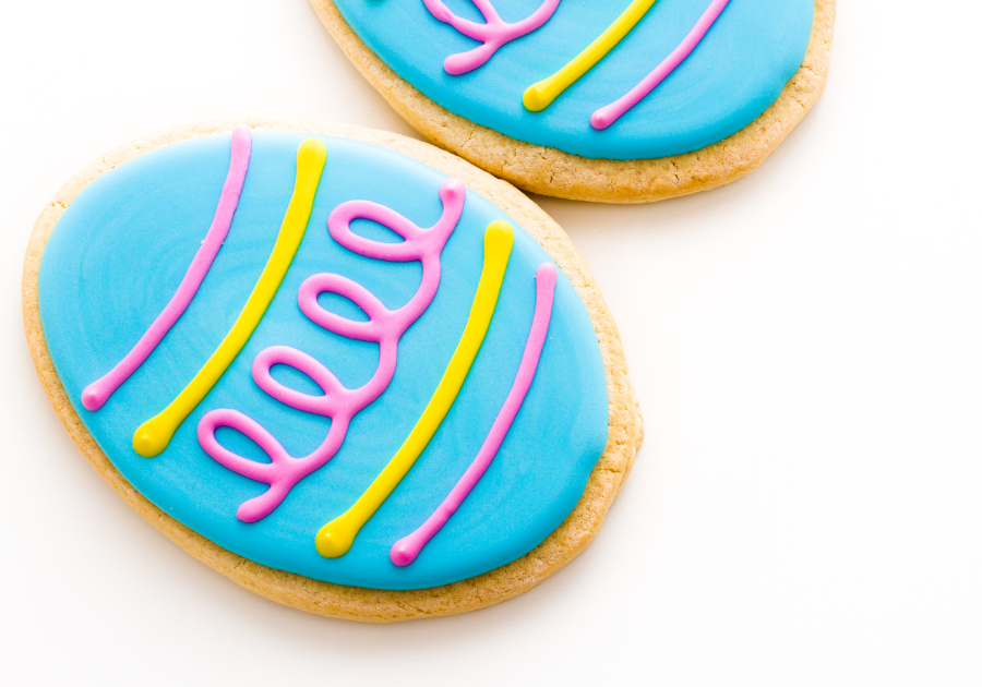 image of decorated egg shaped sugar cookies laying on a white background.