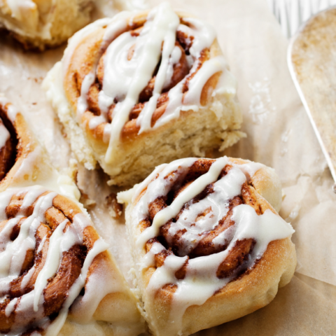 image of sourdough cinnamon rolls laying on parchment paper.